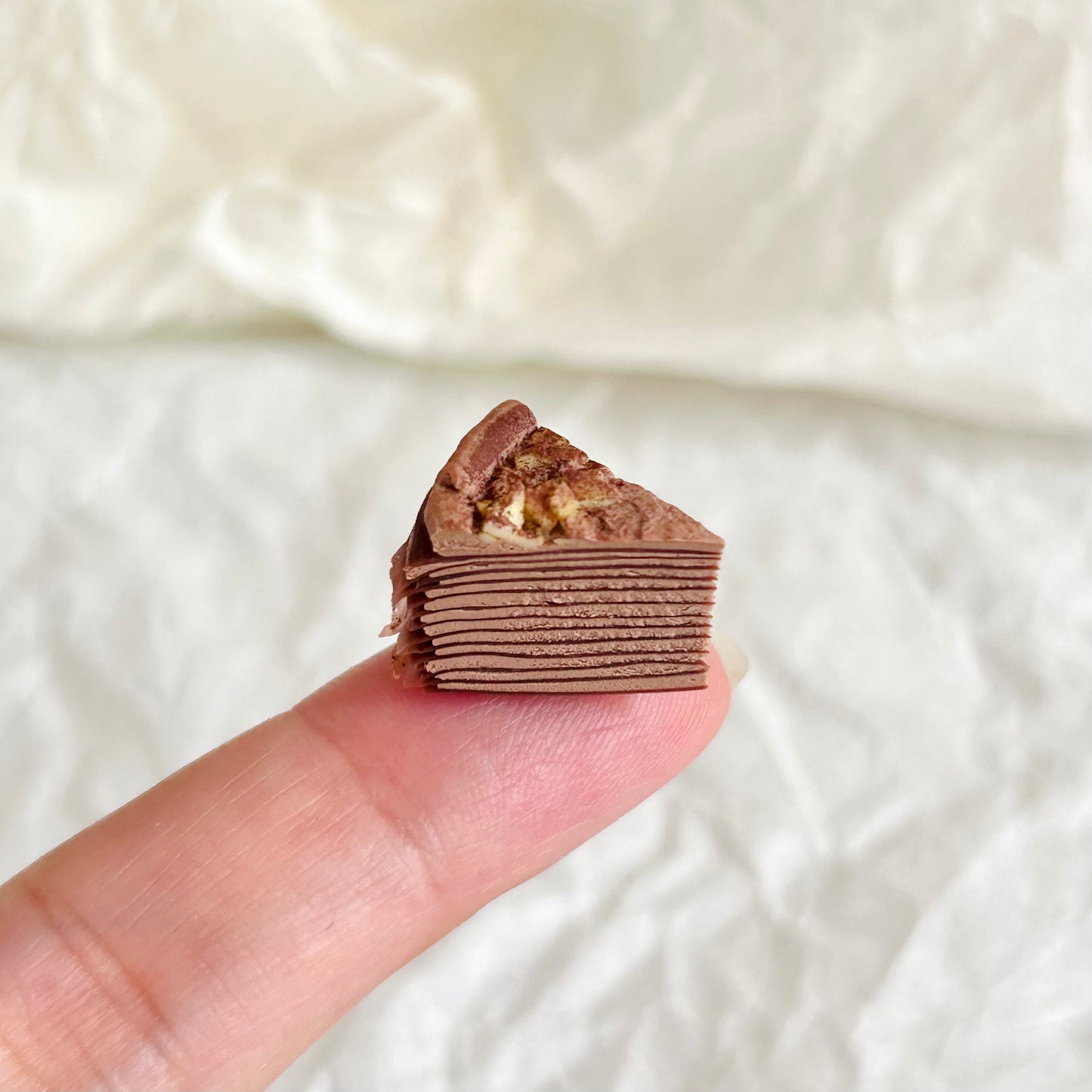 miniature chocolate mille crepe cake with cream and nut topping