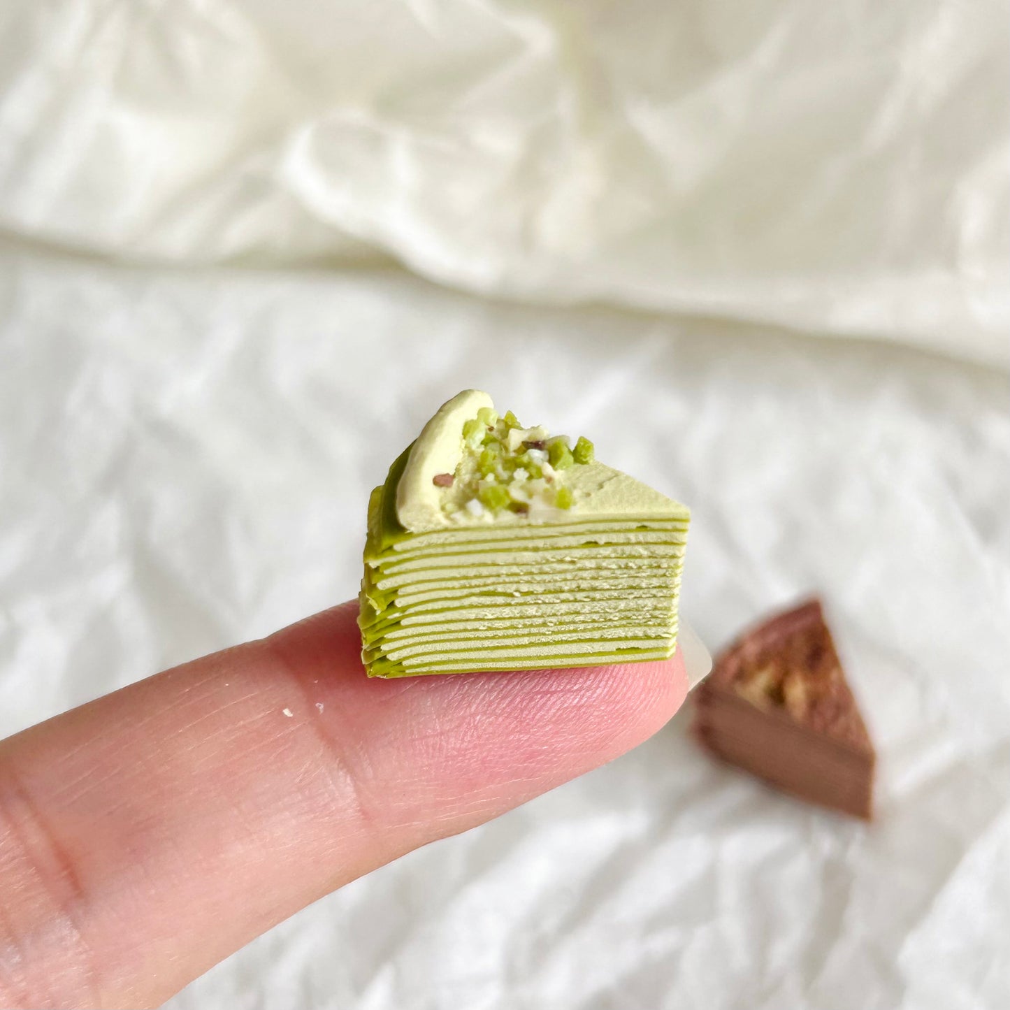 miniature matcha mille crepe cake with cream and nut topping