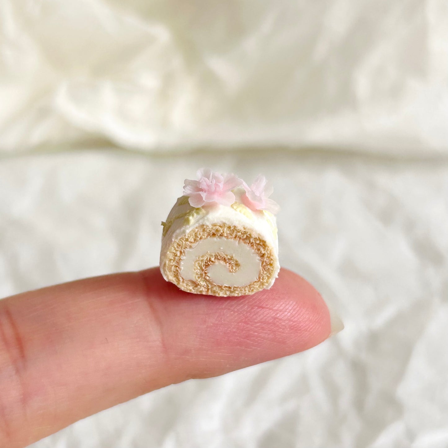 realistic miniature flower Swiss roll held in hand