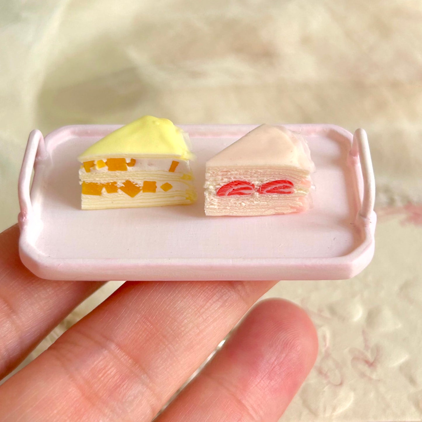 small handmade miniature mille crepe cake slice held in hand