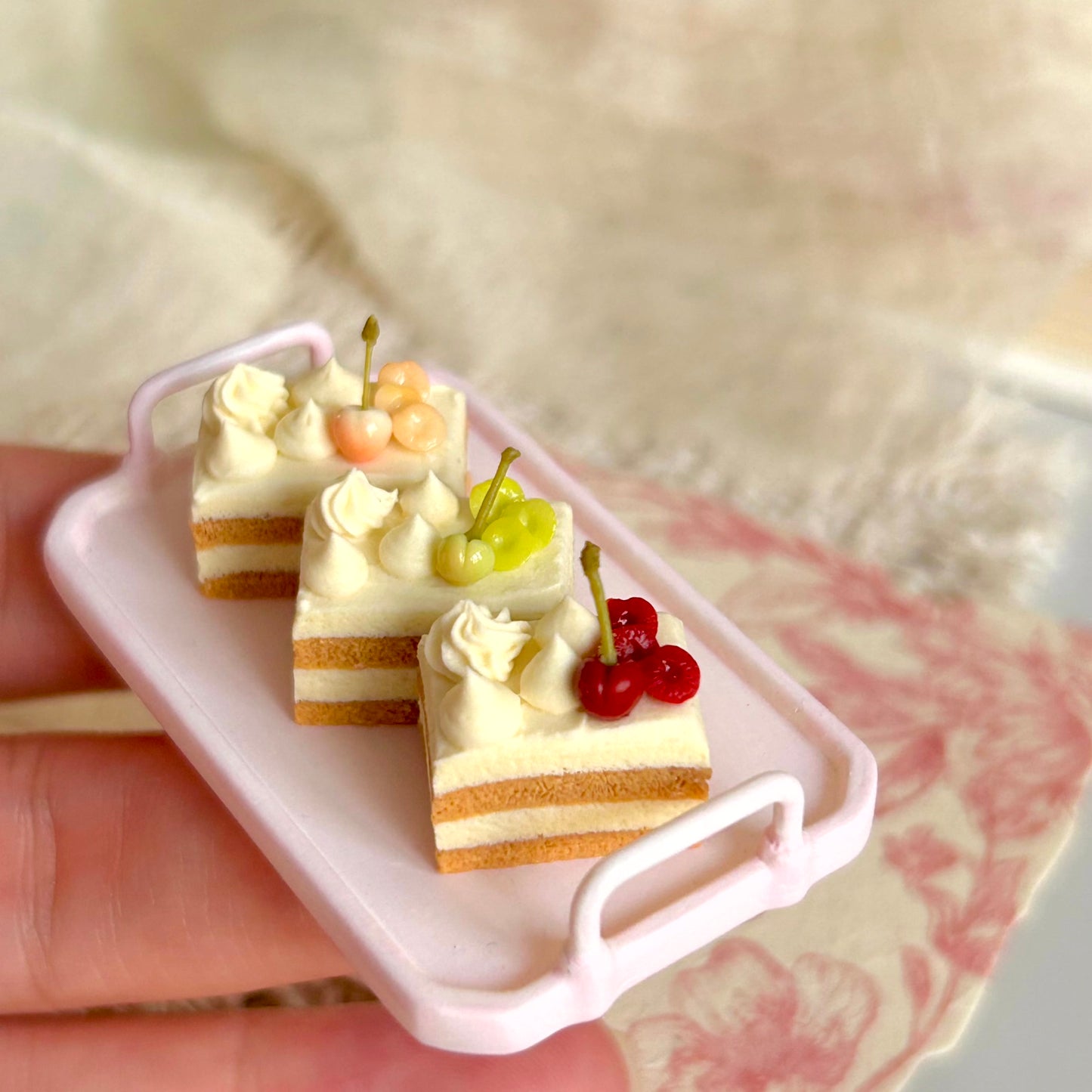 realistic miniature layered cake with cream and cherry details