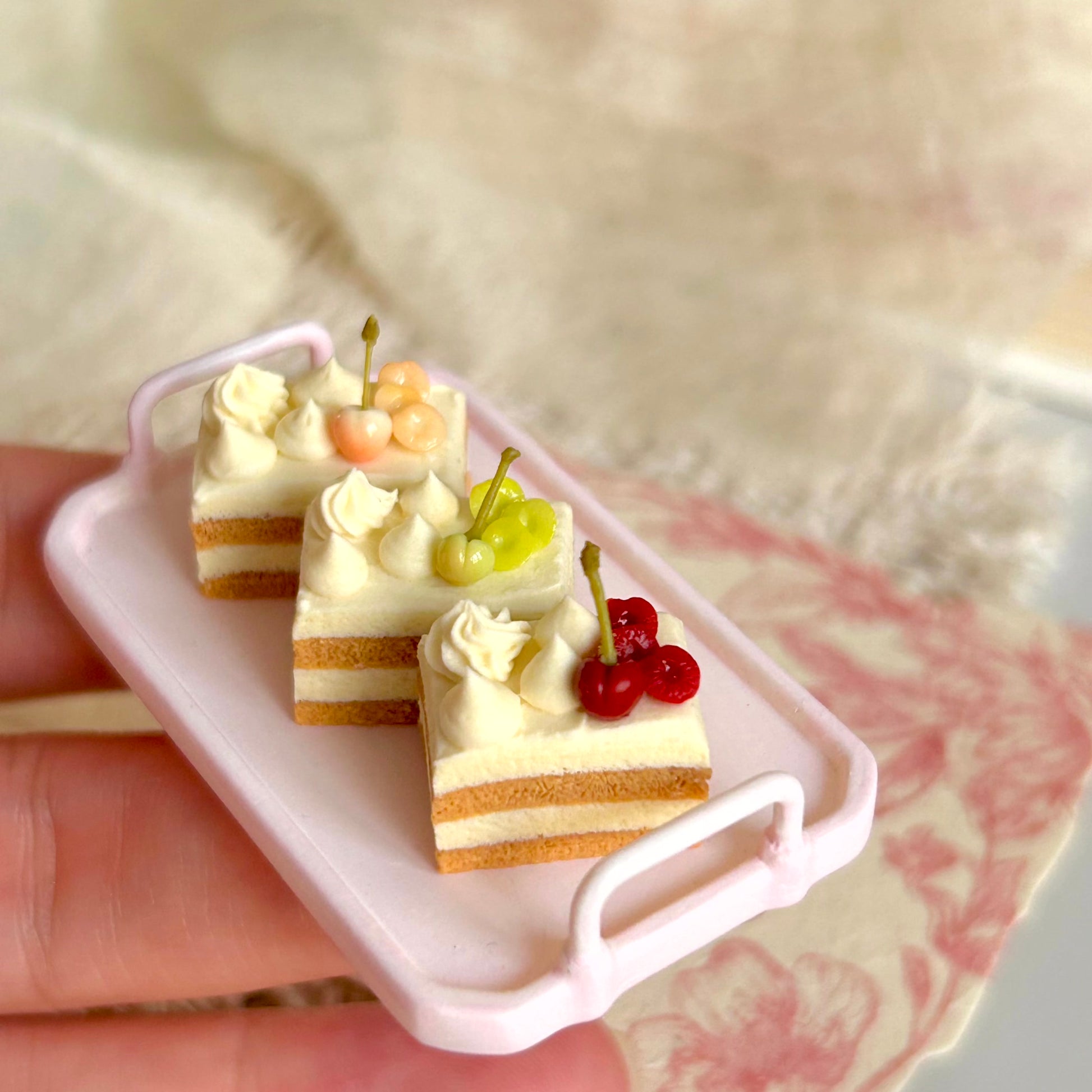 realistic miniature layered cake with cream and cherry details