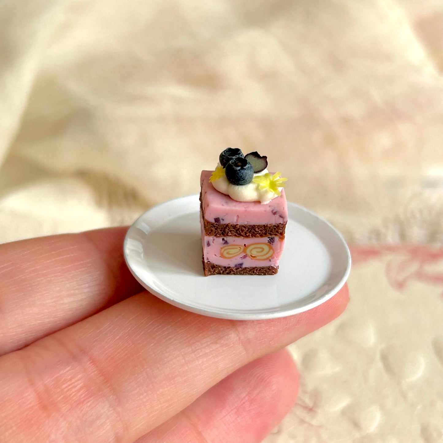 small scale miniature cube cake held in hand